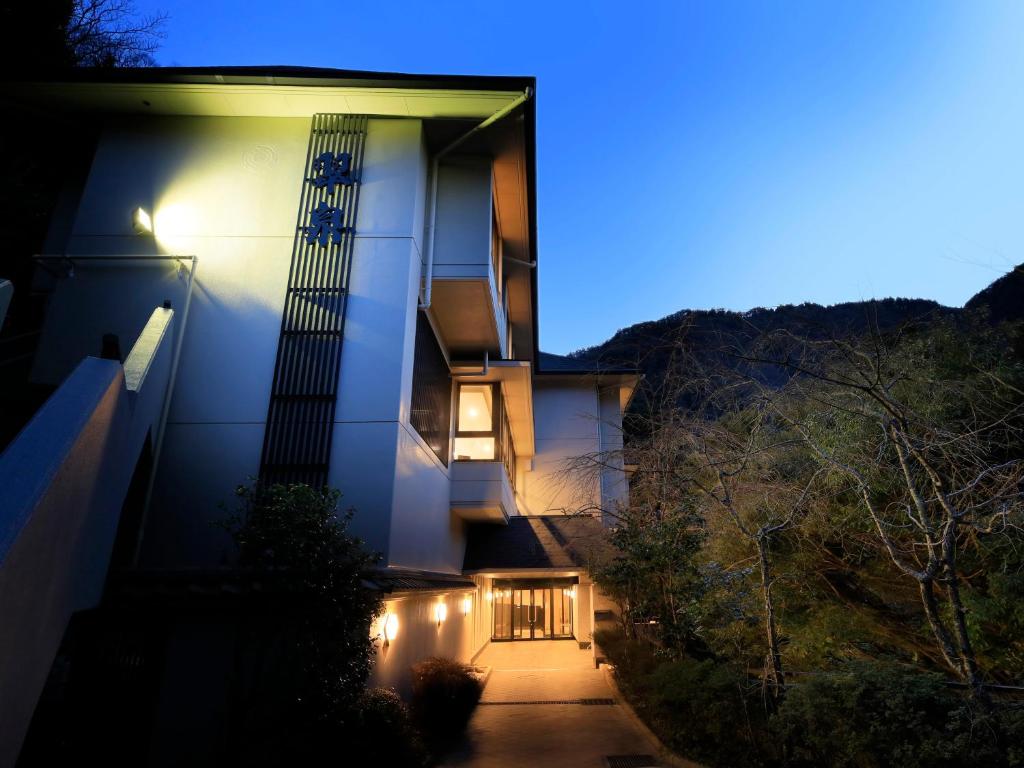 ein Haus in der Nacht mit eingeschaltetem Licht in der Unterkunft Hot Spring Inn Hakone Suisen in Hakone