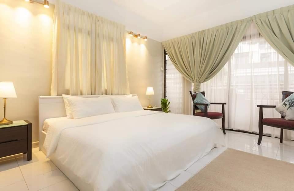 a bedroom with a large white bed and a window at Isabella Villa George Town Penang in George Town
