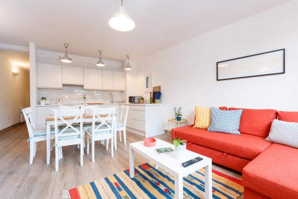 a living room with a red couch and a table at Stylish Soundproof Temple Bar Square in Dublin