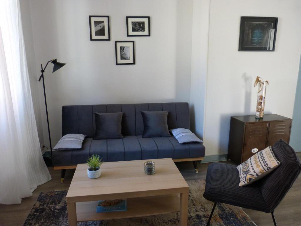 a living room with a blue couch and a table at Appartement Topaze Bourg d'Oisans in Le Bourg-dʼOisans