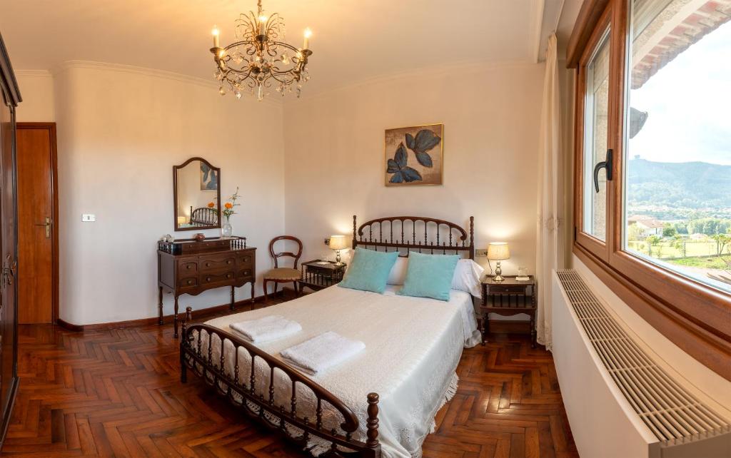 1 dormitorio con cama y ventana grande en Lar de Carmen en Redondela