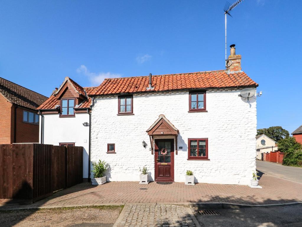 een wit huis met een rood dak bij Chalk Cottage in Thetford