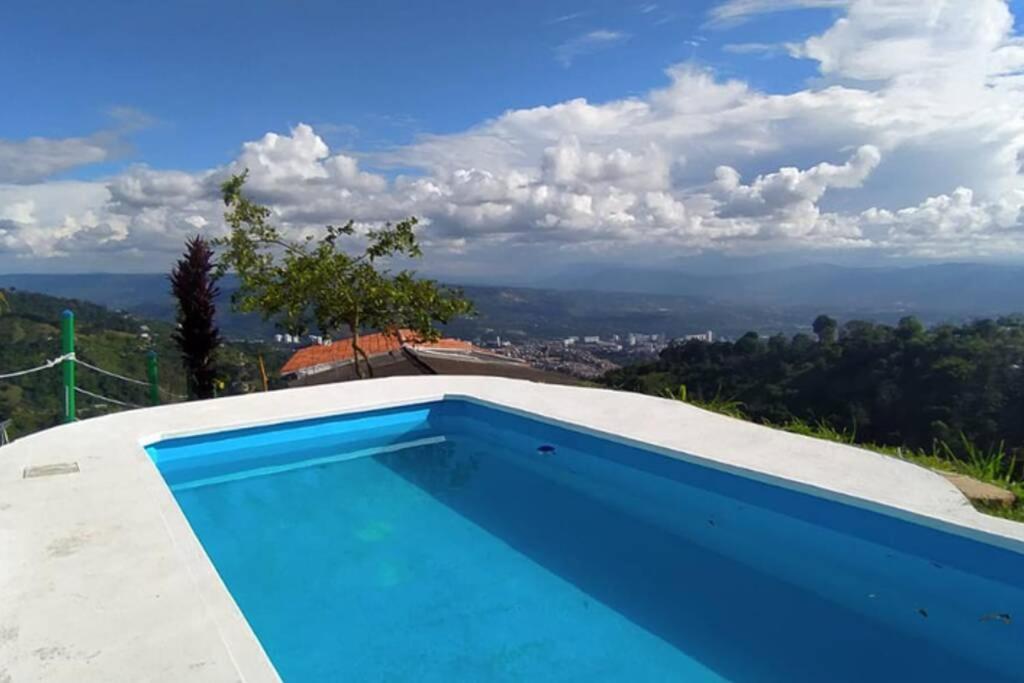 uma piscina ao lado de uma casa em Hermosa finca con vista a la ciudad a 20 min de Bucaramanga em Bucaramanga