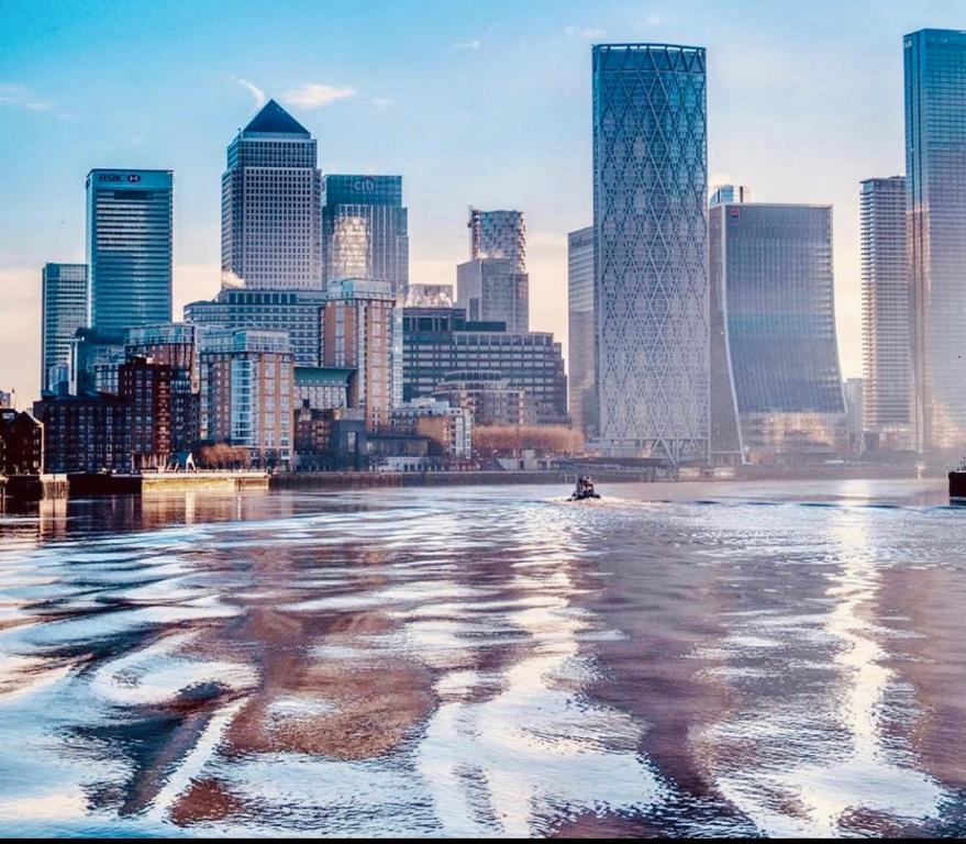uma vista da cidade a partir da água com edifícios em Executive Waterfront Split Penthouse em Woolwich