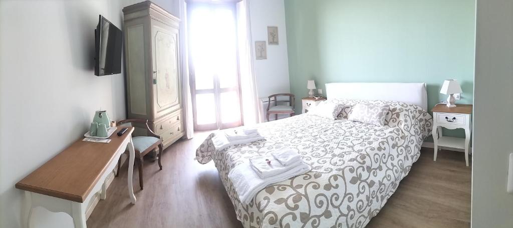Schlafzimmer mit einem Bett, einem Schreibtisch und einem TV in der Unterkunft Al Giardino Segreto in Monza