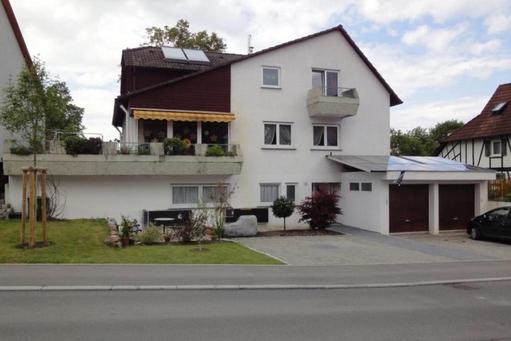 a white house with a balcony on a street at OG Villingendorf in Villingendorf