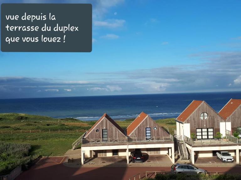 ein großes Haus mit dem Ozean im Hintergrund in der Unterkunft Résidence La Naturelle in Wimereux