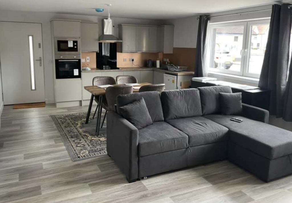 uma sala de estar com um sofá e uma cozinha em Lochaber Apartments em Fort William