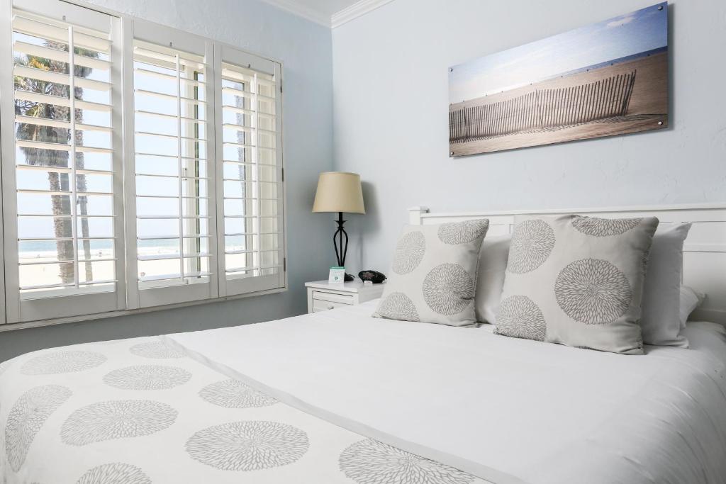 a bedroom with a white bed with white pillows at Venice on the Beach Hotel in Los Angeles