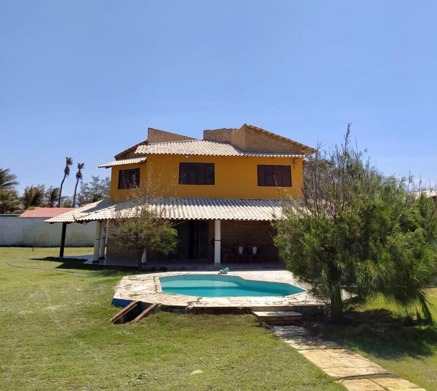 une maison avec une piscine en face de celle-ci dans l'établissement Casa de Praia no Morro Branco, à Beberibe