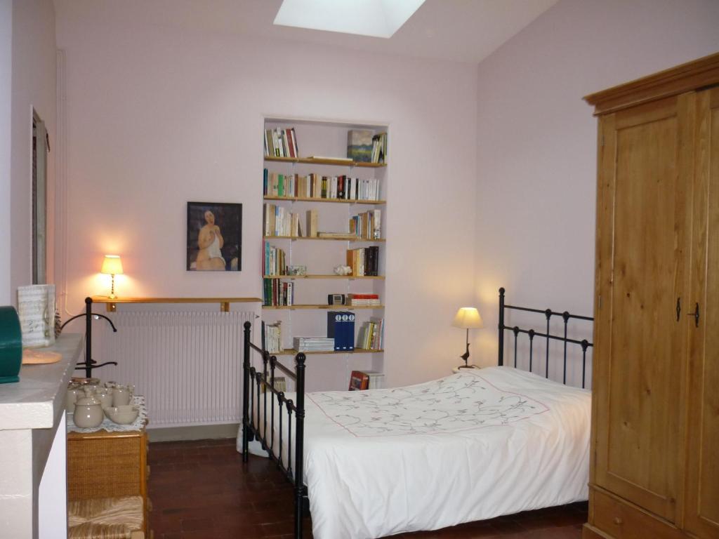 1 dormitorio con cama y estante para libros en Chambre d'hôtes - Dodo et tartines, en Bayeux