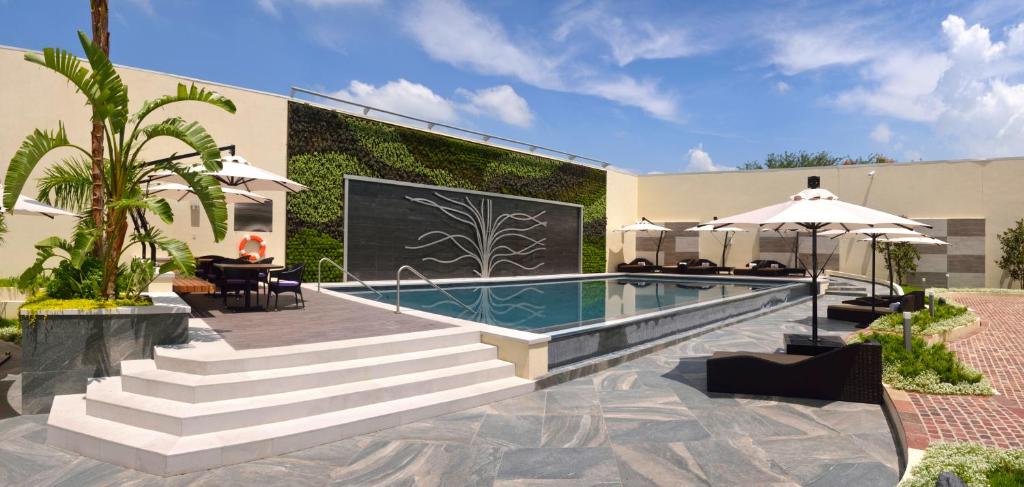une maison avec une piscine et des escaliers à côté d'un bâtiment dans l'établissement HS HOTSSON Hotel Silao, à Silao