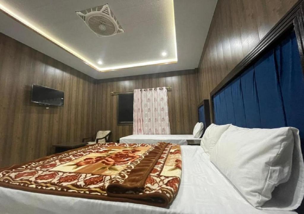 a bedroom with a bed with a blanket on it at Oriole Guest House Economy Living in Islamabad