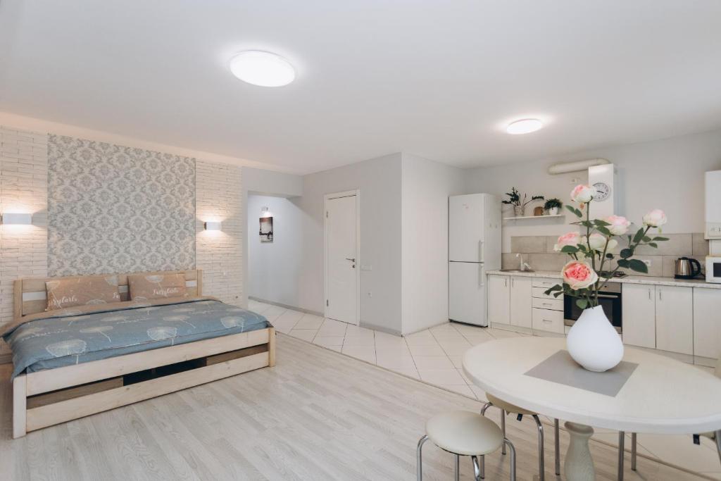 a bedroom with a bed and a table and a kitchen at Apart-Hotel in Sumy
