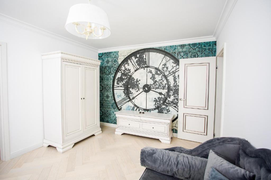a living room with a large clock on the wall at Apartament Amaya in Bistriţa