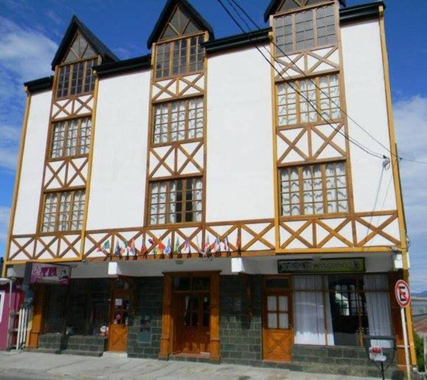 um grande edifício com grandes janelas numa rua em Posada del Pinguino em Ushuaia