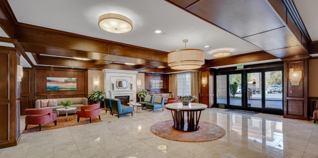 a large lobby with a table and chairs and a living room at Ayres Hotel & Spa Moreno Valley/Riverside in Moreno Valley