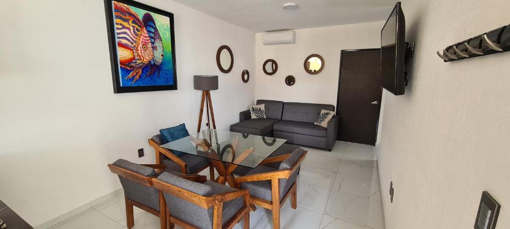 un soggiorno con tavolo, sedie e divano di Departamento en condominio con alberca y área infantil a Manzanillo