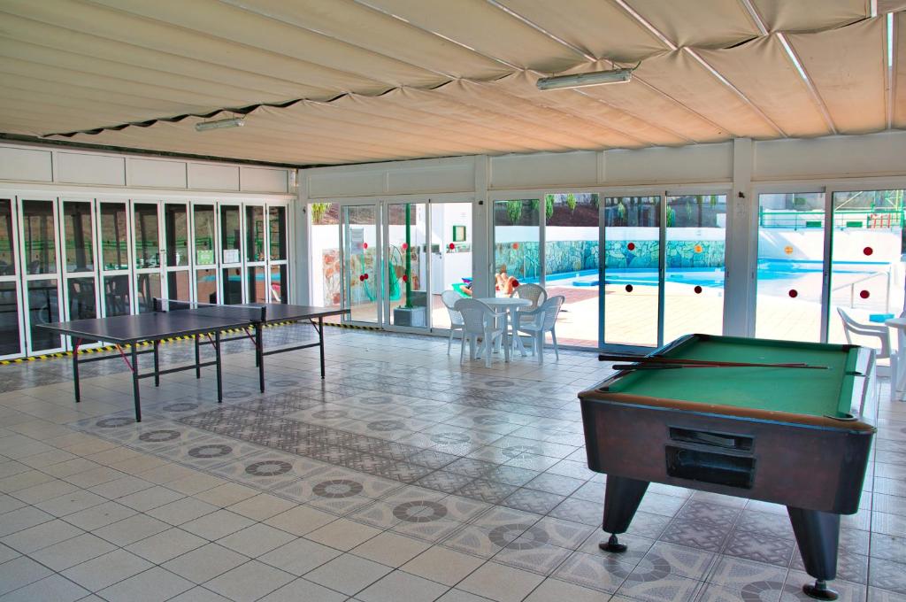 pokój z 2 stołami do ping ponga i basenem w obiekcie Malibu apartamento con campo de tennis y piscina con solarium w mieście Puerto Rico de Gran Canaria