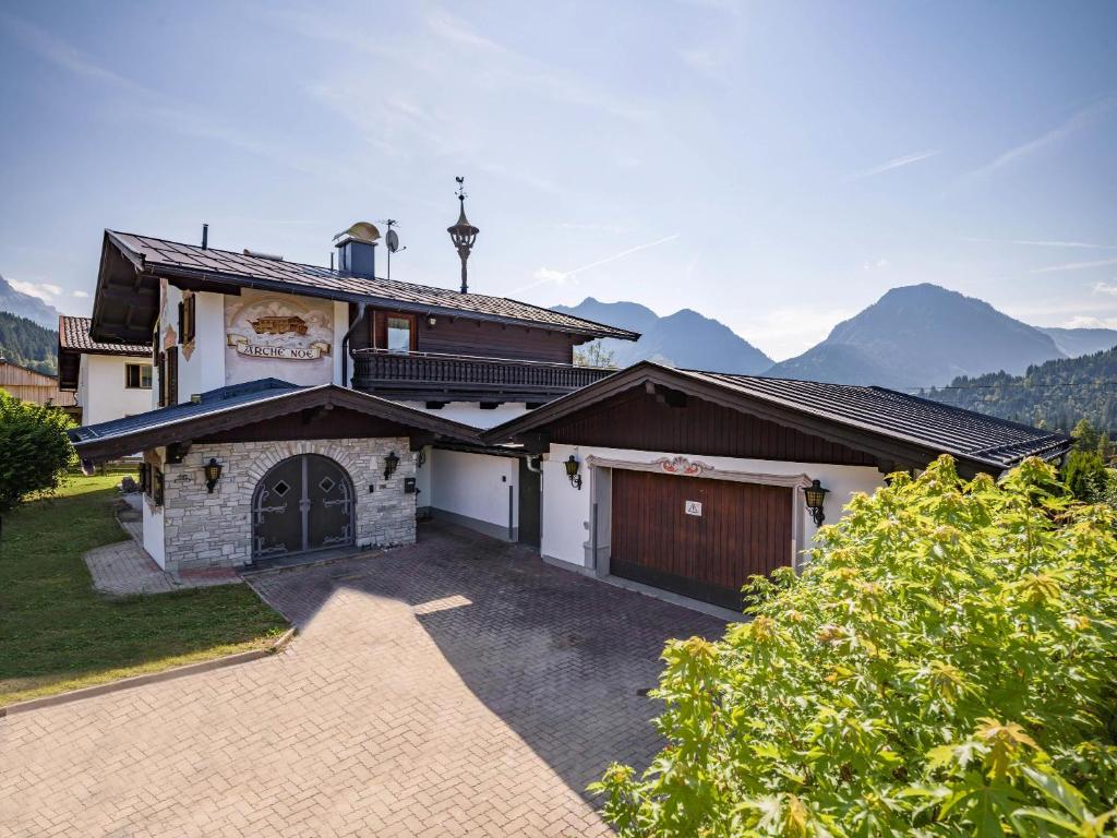 dom z garażem i góry w tle w obiekcie Exclusive Villa Tirol w mieście Fieberbrunn