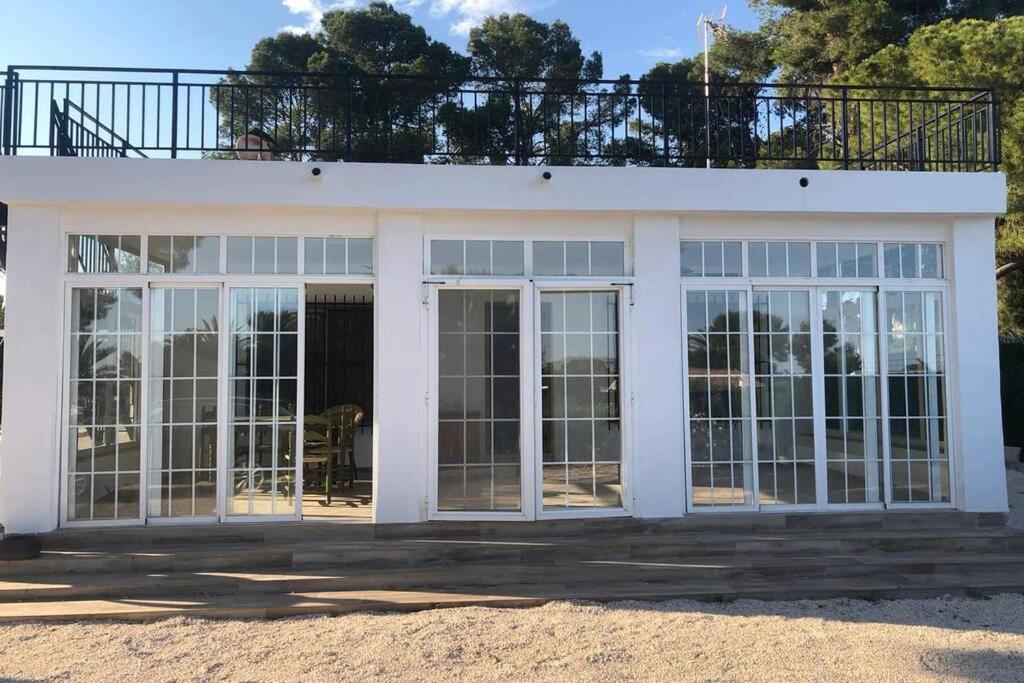 ein weißes Haus mit großen Glasschiebetüren in der Unterkunft Casa rural con piscina / Cottage house with swimming pool in Elche