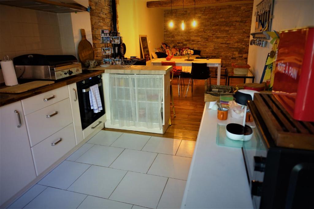 a kitchen with white tile floors and a counter top at Maison Small Luxury ( planxa,suite,solarium,jacuzzi,pas de vis à vis) in Argelès-sur-Mer