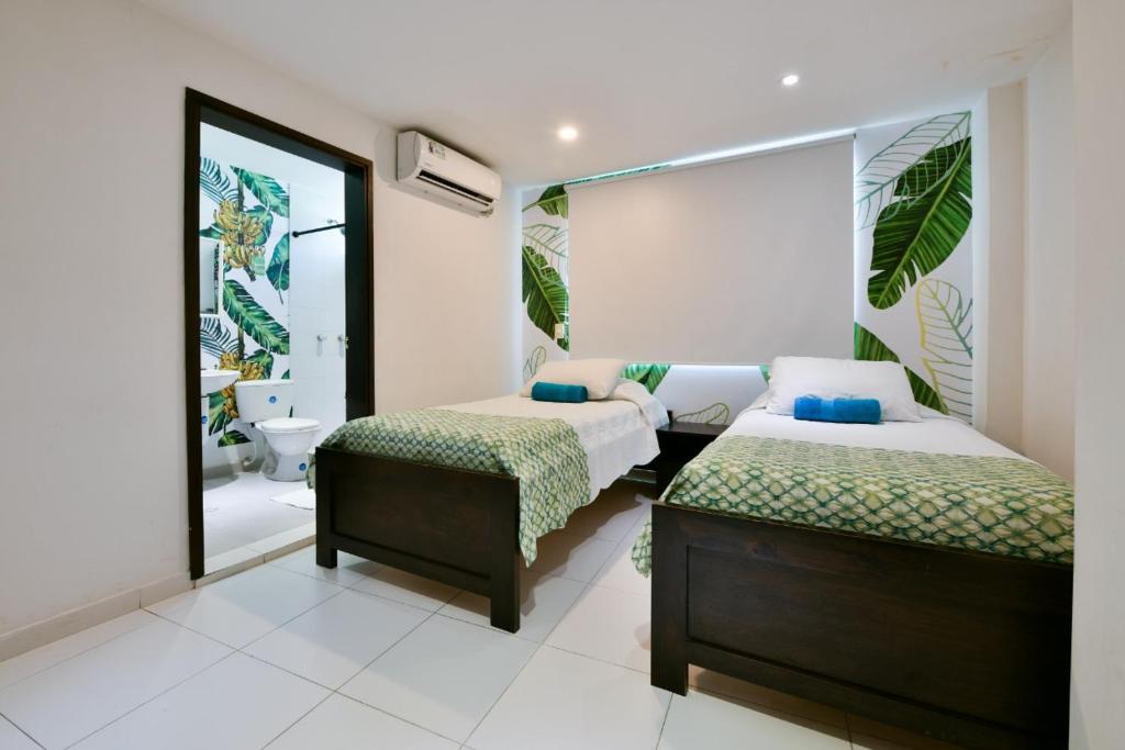 a bedroom with two beds and a bathroom at Tropical Breeze Apartamentos in San Andrés