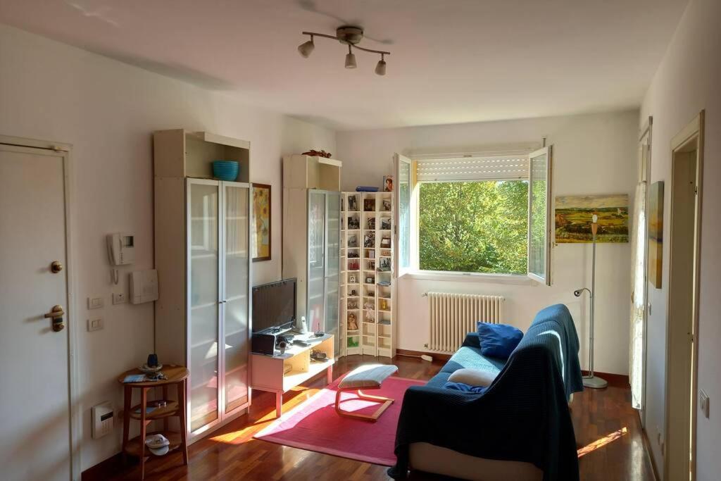 a living room with a blue couch and a window at Carachouse - Bologna in Bologna