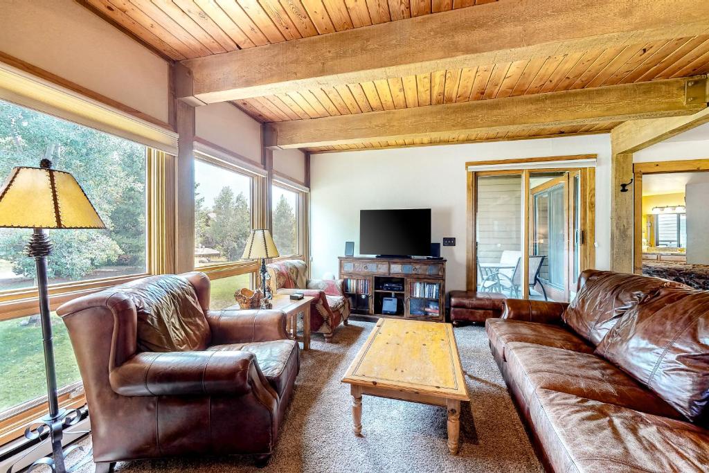 a living room with leather furniture and a large window at Lodge at Steamboat B205 in Steamboat Springs