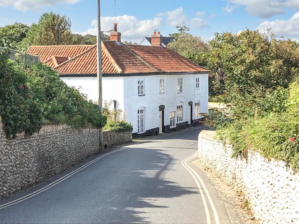 a white house on the side of a road at Cobbler's Cottage in Norwich