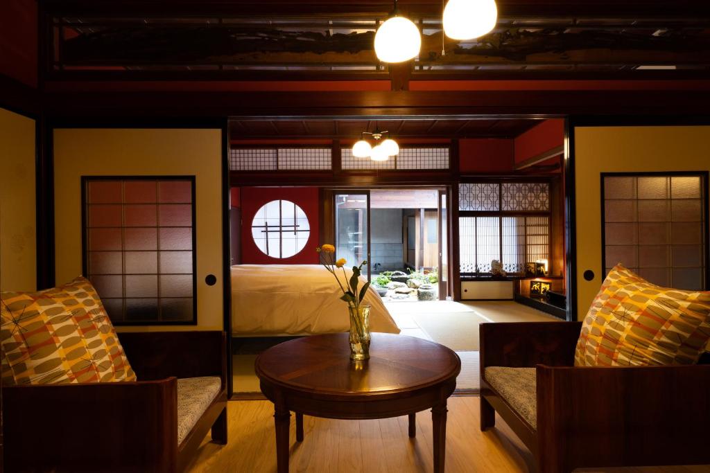 a living room with a bed and a table and chairs at 龍助２５ in Komatsu