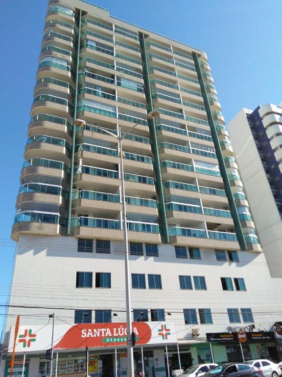 a tall apartment building with a parking lot in front of it at D frente Green D 3 in Vila Velha