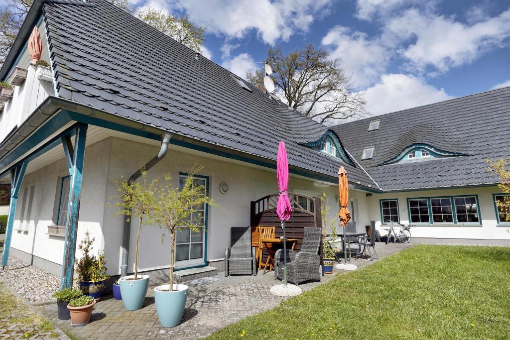 a house with a patio with chairs and umbrellas at Seerano in Zingst
