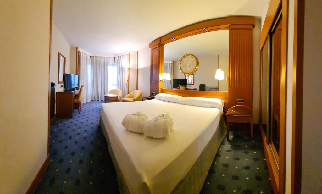 Una habitación de hotel con una cama grande con dos toallas. en Hotel los Bracos en Logroño