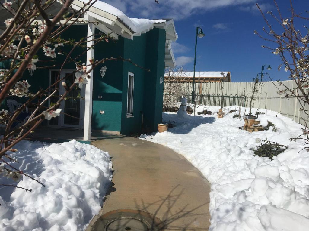 una casa cubierta de nieve junto a una entrada en החן בירוק, en El-Rom