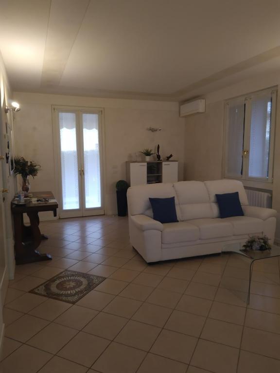 een woonkamer met een witte bank en een tafel bij nido di dafne in Provaglio d'Iseo