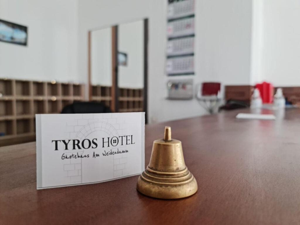 a brass bell sitting on a table next to a box at Tyros Hotel und Gästehaus am Weidendamm in Hannover