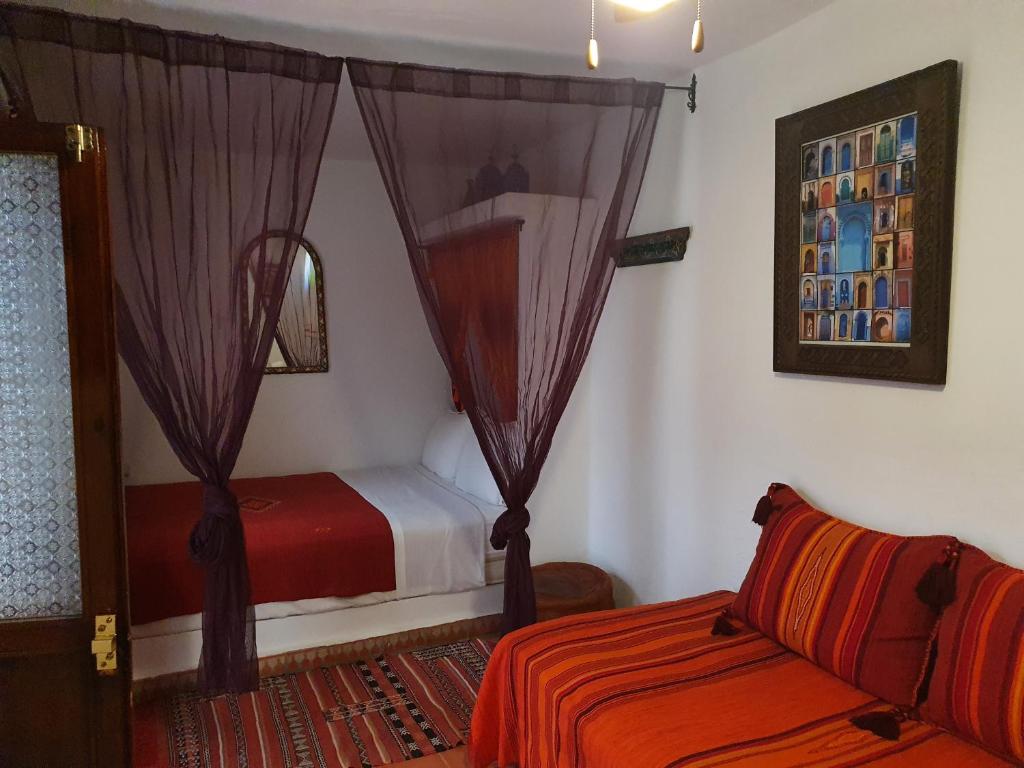 a bedroom with a bed and a couch in a room at Casa La Palma in Chefchaouene