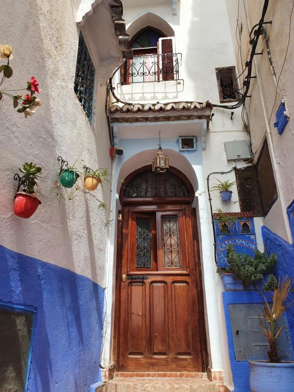 a wooden door on the side of a building at Casa La Palma in Chefchaouene