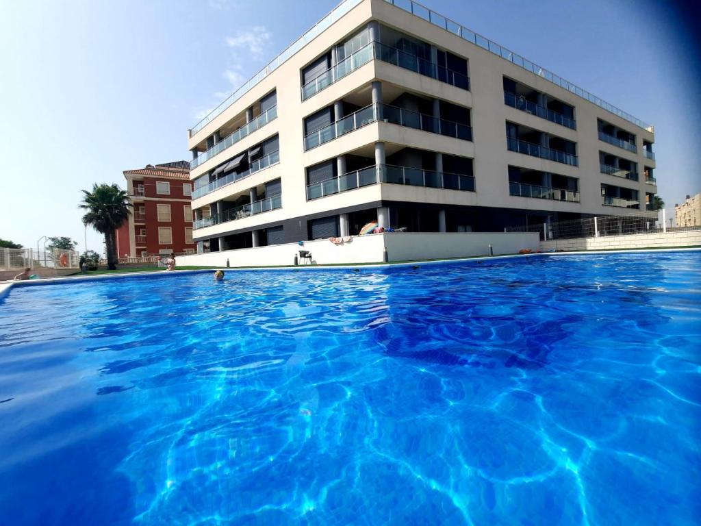 a large swimming pool in front of a building at Pinada Beach IV new & comfort. apartment, 1st line to the beach, sunterrace+pool in La Mata