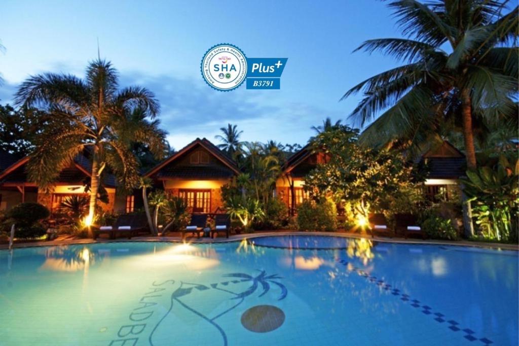 a villa with a swimming pool at night at Salad Beach Resort - SHA Extra Plus in Salad Beach