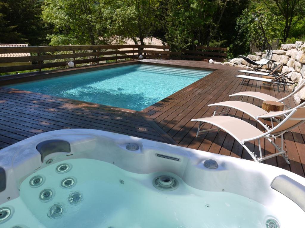 d'une baignoire installée à côté de la piscine. dans l'établissement Le Cypressat, à Les Plans