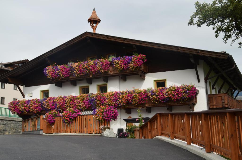 a building with flowers on the side of it at Pension Kirchbrugger in Telfes im Stubai