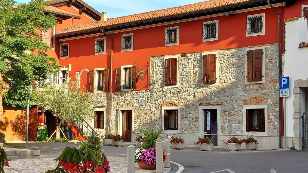 a large brick building with a red at Hotel Locanda Al Pomo d'Oro in Cividale del Friuli