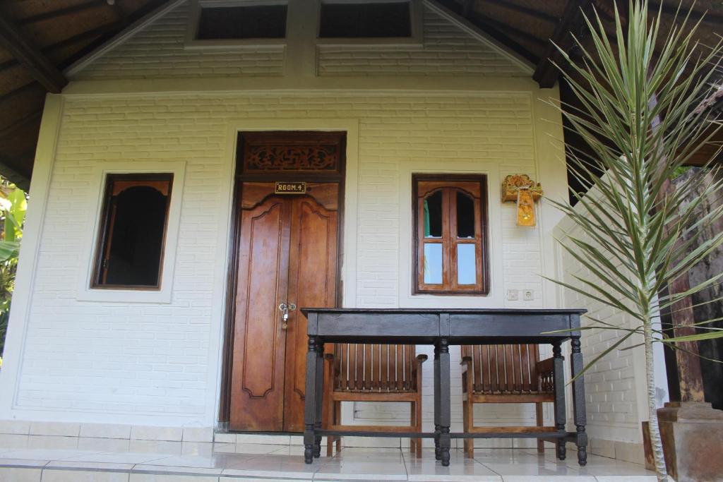 a house with a black table in front of it at Pondok Lembah Dukuh Homestay in Tirtagangga