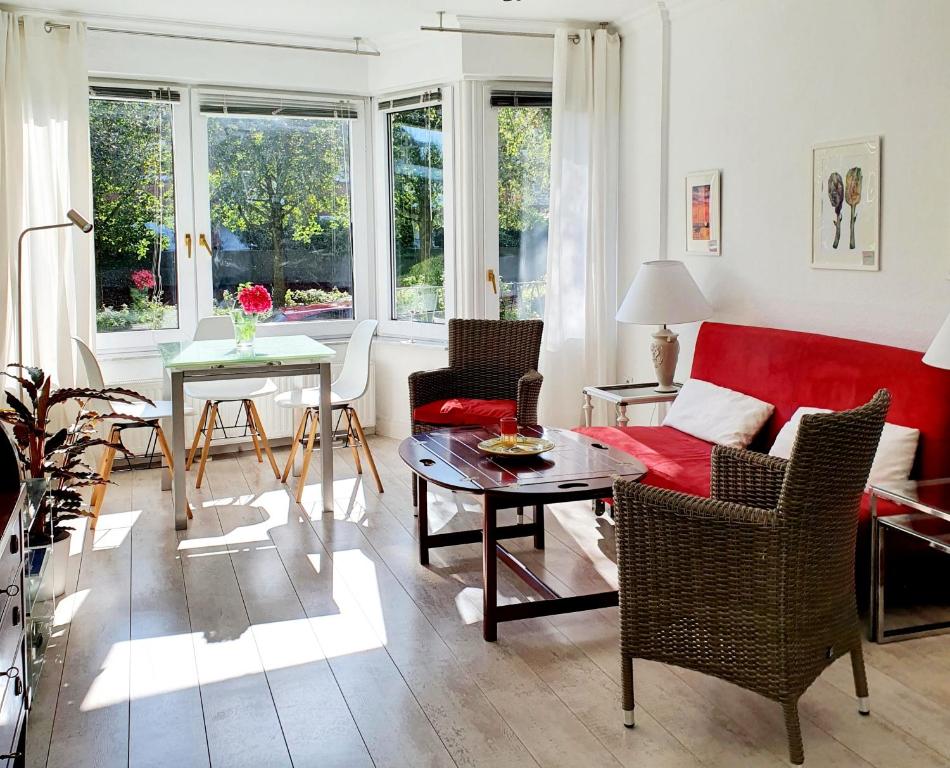 sala de estar con sofá rojo y mesa en Hamburg Niendorf-Suite en Hamburgo