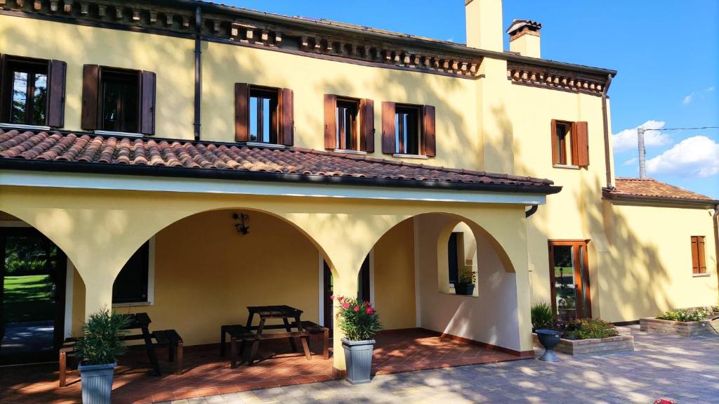 a large white building with a patio in front of it at Agriturismo La Foscarina in Vescovana