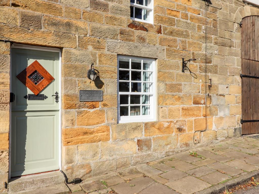 un edificio de piedra con puerta y ventana en Michaelmass Cottage, en Whitby