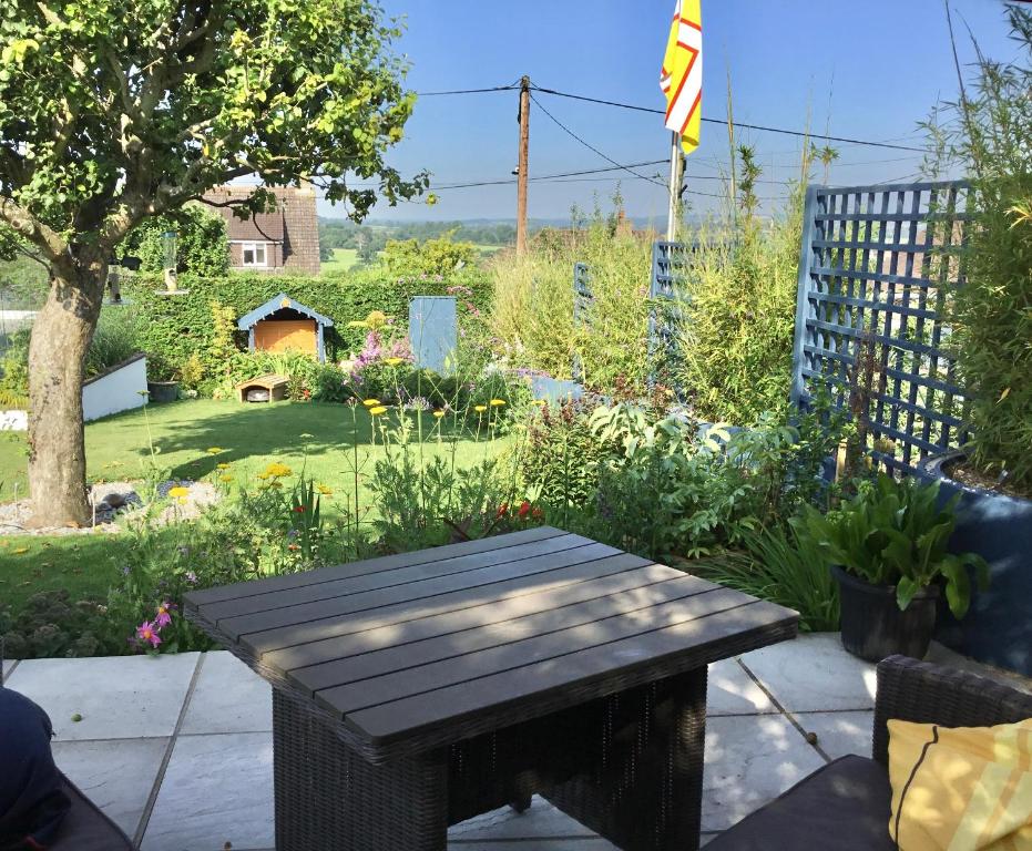 a wooden picnic table sitting in a garden at Bed@BroadOak in Sturminster Newton