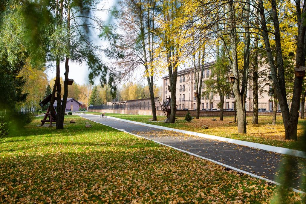 a path in a park with trees and a building at Grand Hotel & Spa Aristokrat Kostroma in Kostroma